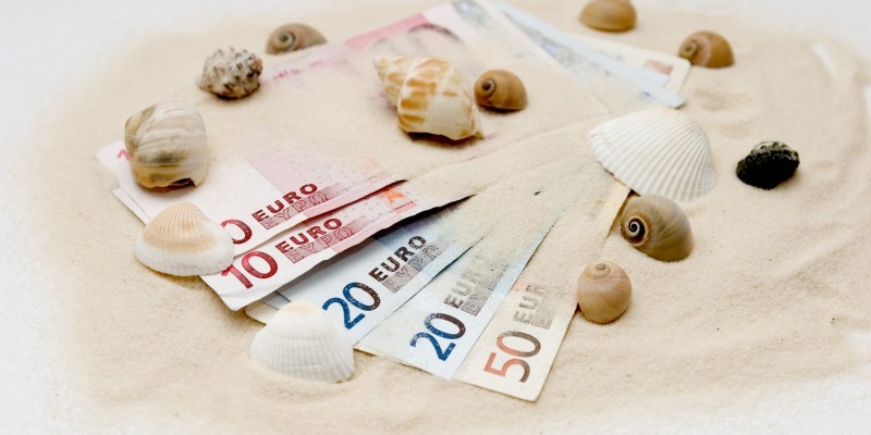 Geldscheine mit Sand und Muscheln